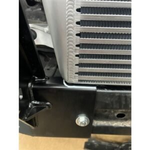 Close-up of an intercooler mounted on a black steel bracket with visible bolt fitting.