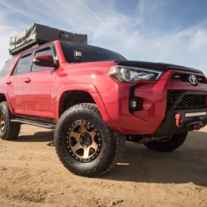 Red Toyota 4Runner equipped with Method Race Wheels 310 Con 6 Bronze on a sandy beach.