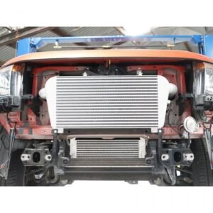Front-mounted intercooler kit installed on a 4x4 vehicle for improved turbo performance.
