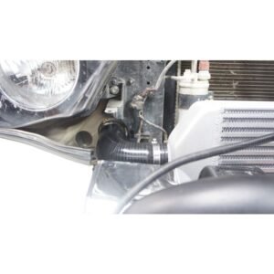 Complete Intercooler Kit with Piping and Installation Hardware Aftermarket intercooler piping and silicone hose connected near headlight and radiator support