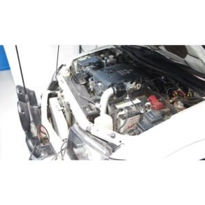 Complete Intercooler Kit with Piping and Installation Hardware Mitsubishi Triton engine bay with white aluminum intercooler piping and upgraded turbo system