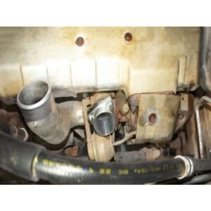 Close-up view of turbocharger outlet pipe and mounting bracket on a vehicle engine