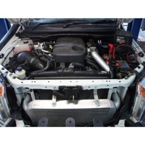 Turbo diesel engine bay with front mount intercooler installed for improved cooling and performance.