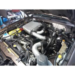 Nissan Patrol engine bay fitted with aftermarket top-mount intercooler and upgraded piping.