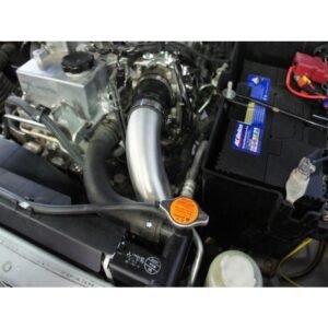 Engine bay with upgraded intercooler piping connected to turbocharger.